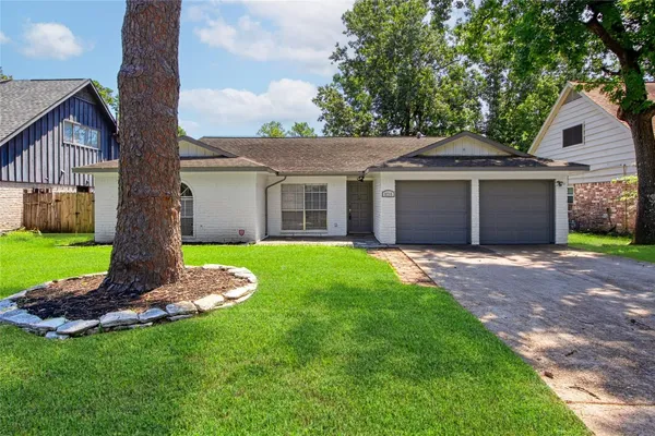 a front view of a house with a garden and yard