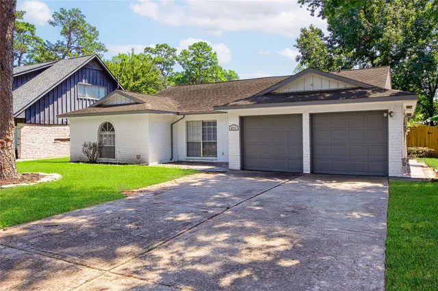 a view of a house with a yard and large tree