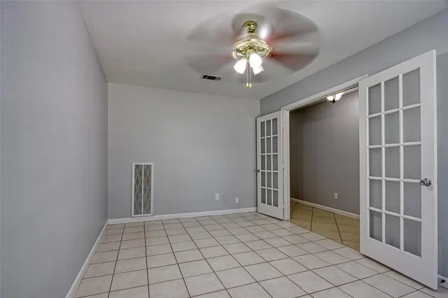 an empty room with closet and chandelier fan