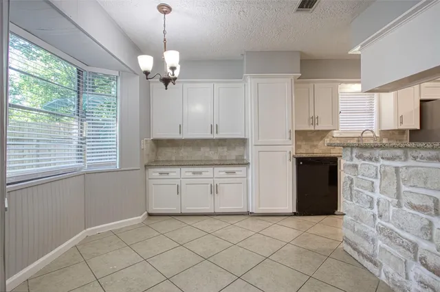 a kitchen with granite countertop a sink cabinets and window