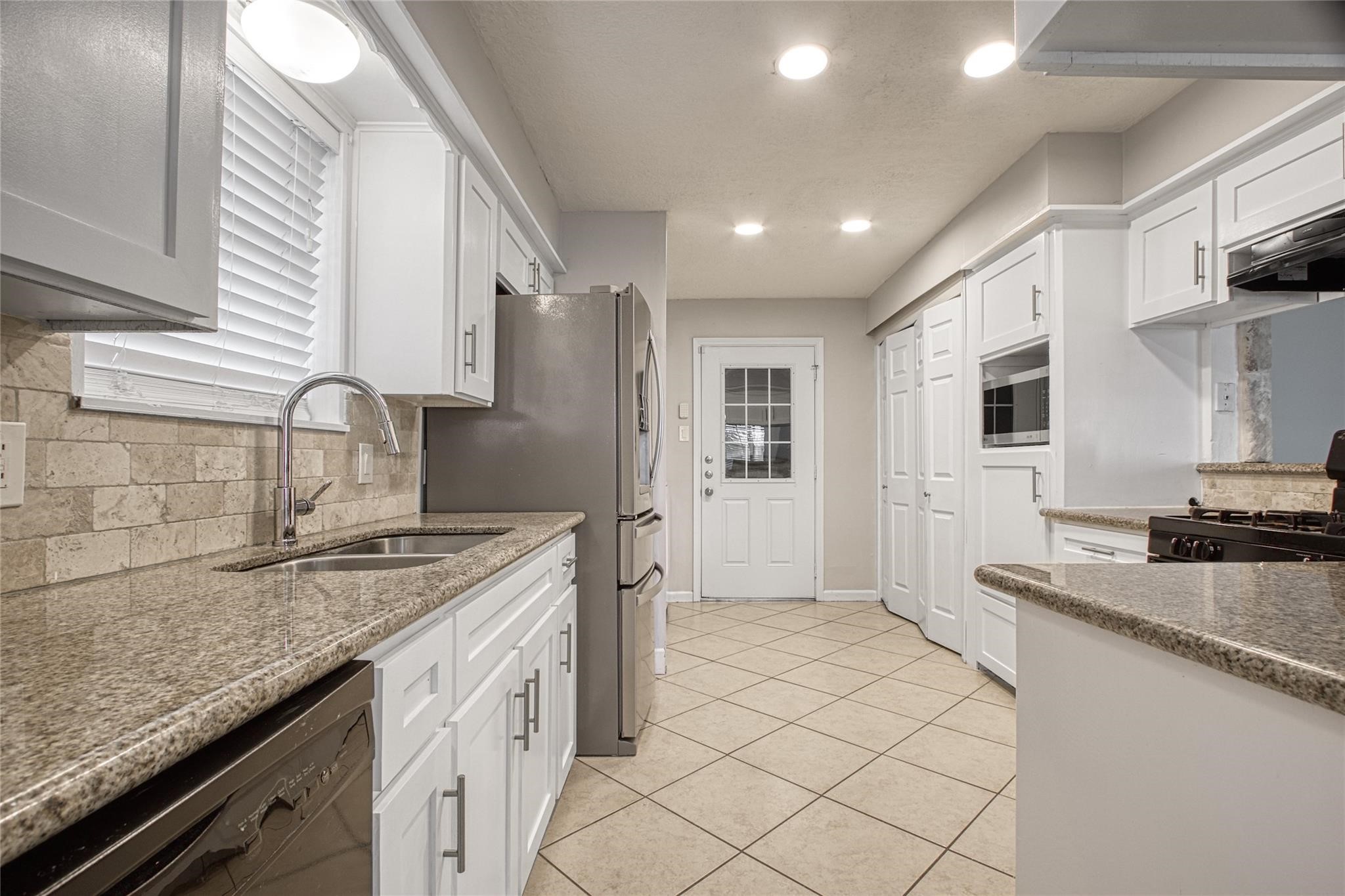 9715 Ballin David Drive Spring, TX 77379 - Photo 9 of 20 a kitchen with a sink stove and cabinets