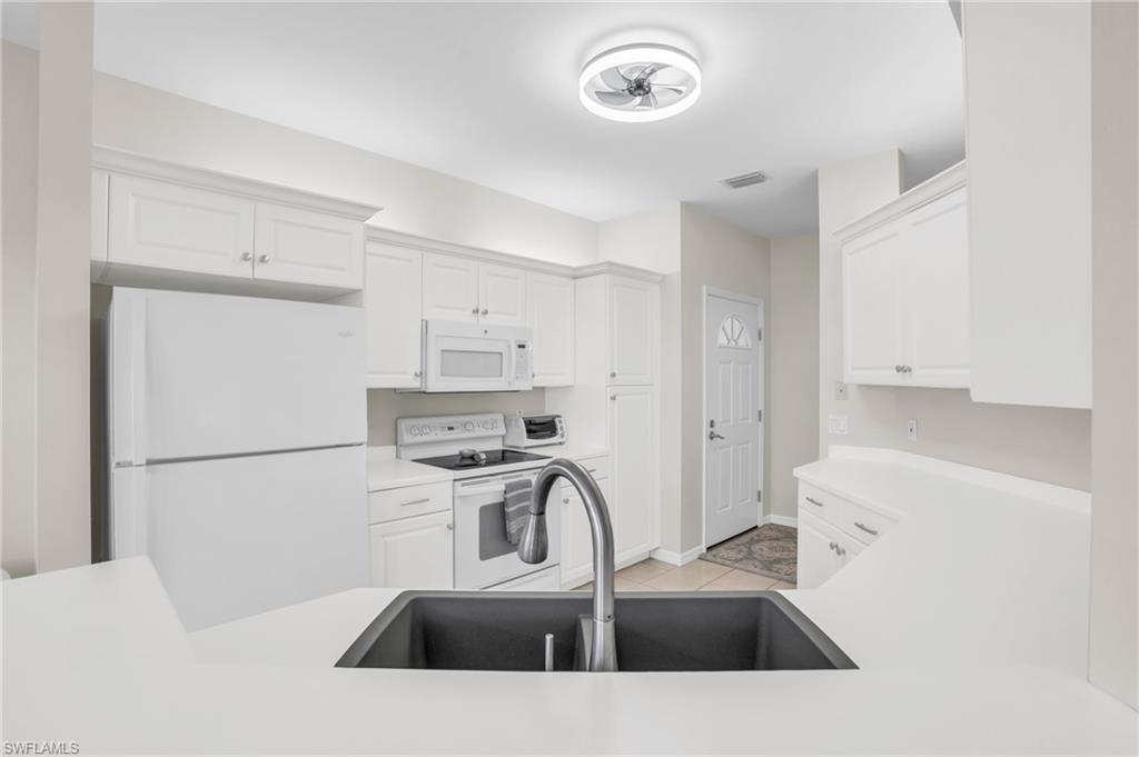 6025 Pinnacle Lane, Unit 602 Naples, FL 34110 - Photo 11 of 43 a kitchen with a sink a stove and refrigerator
