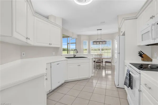 a kitchen with white cabinets and white appliances