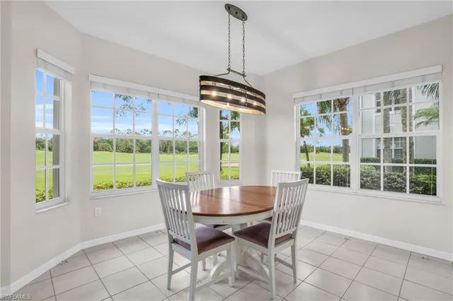 a dining room with furniture large windows and wooden floor