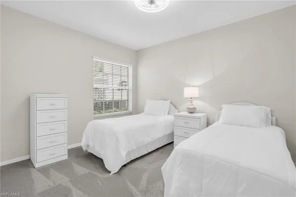 a bedroom with two beds and a window
