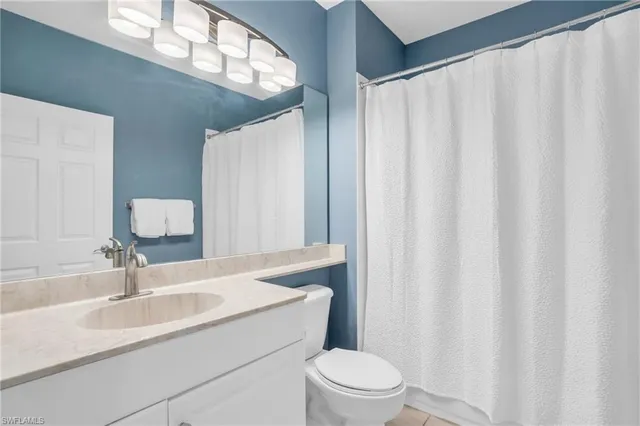 a bathroom with a sink a toilet and shower curtain