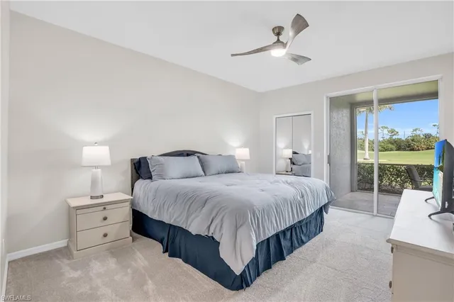 a spacious bedroom with a bed a table and large window with garden view