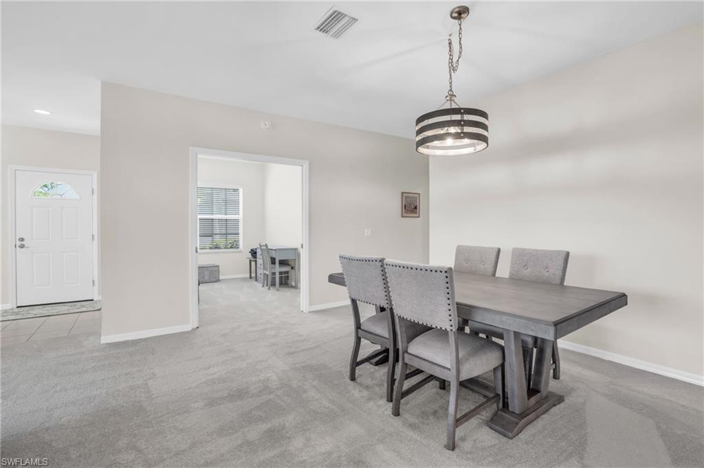 6025 Pinnacle Lane, Unit 602 Naples, FL 34110 - Photo 9 of 43 a view of a dining room with furniture and wooden floor