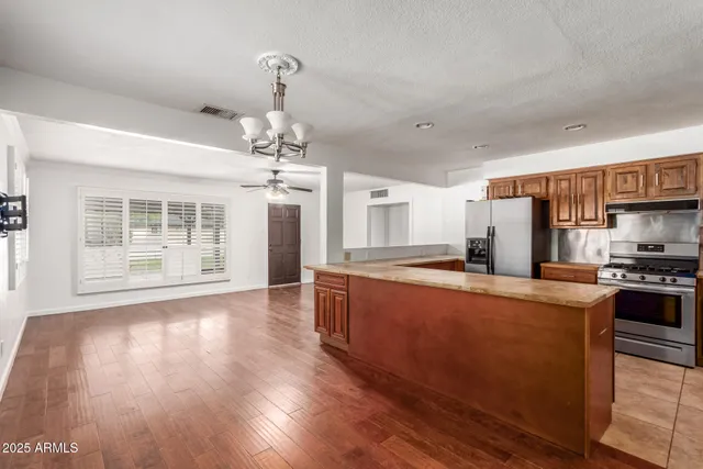 a kitchen with stainless steel appliances granite countertop a refrigerator and a sink