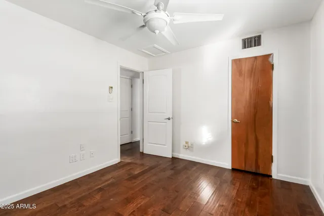 an empty room with fan and windows