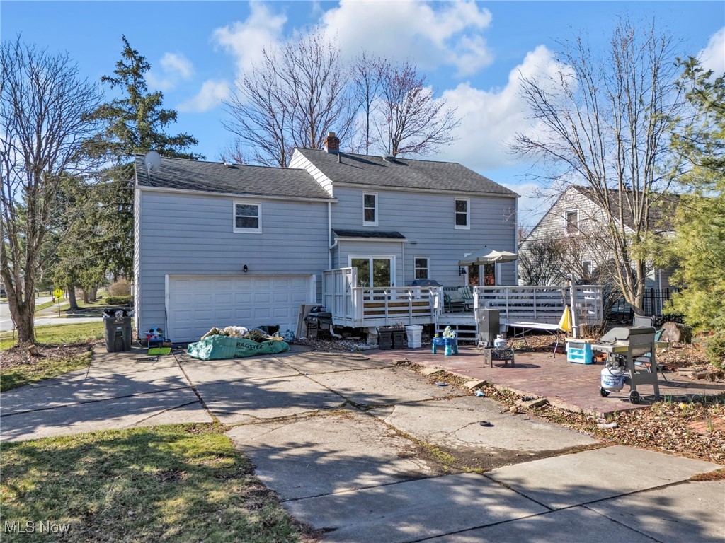 5265 East Farnhurst Road Cleveland, OH 44124 - Photo 26 of 28 Back of property featuring a patio, an attached garage, a chimney, concrete driveway, and a deck