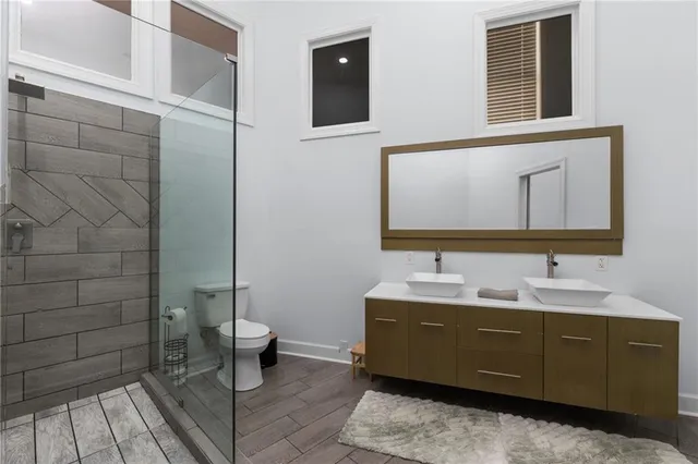 a bathroom with a granite countertop double vanity sink and mirror