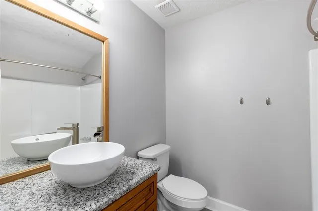 a bathroom with a granite countertop sink and white cabinets