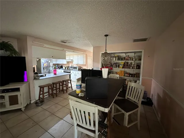 a living room with furniture a flat screen tv and a table