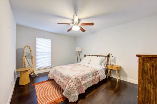a bedroom with a bed flat screen tv and wooden floor