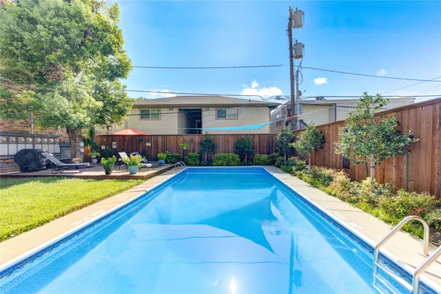 a view of swimming pool with outdoor seating and a tree