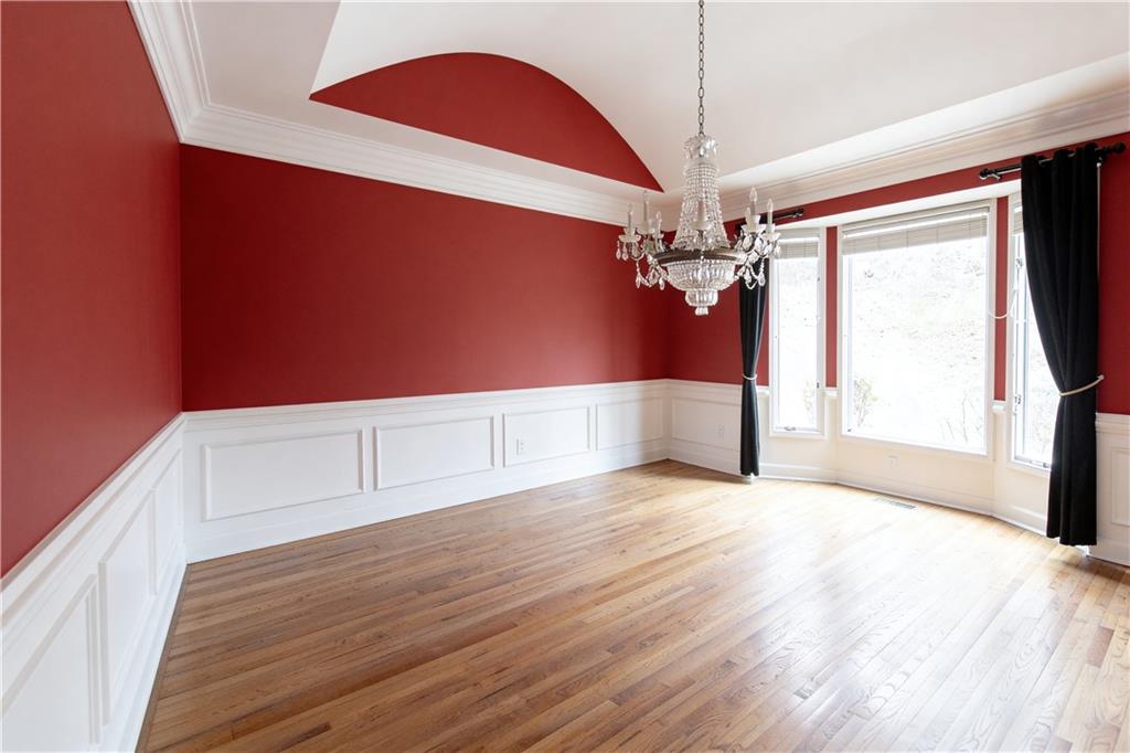 10060 Buice Road Alpharetta, GA 30022 - Photo 20 of 75 a view of a hallway with a chandelier and wooden floor