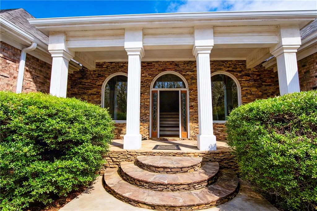 10060 Buice Road Alpharetta, GA 30022 - Photo 2 of 75 a view of a house with potted plants and a fountain