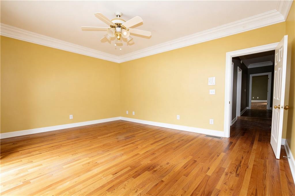 10060 Buice Road Alpharetta, GA 30022 - Photo 22 of 75 a view of a big room with wooden floor and a chandelier fan