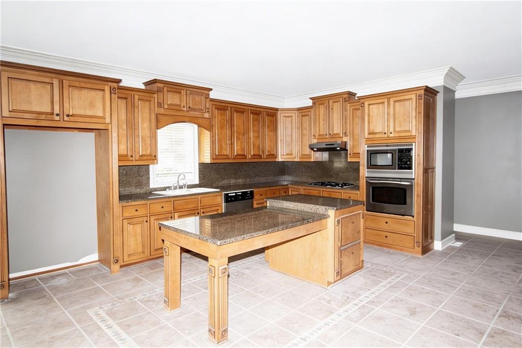 10060 Buice Road Alpharetta, GA 30022 - Photo 29 of 75 a kitchen with stainless steel appliances granite countertop a refrigerator a stove and a sink with cabinets