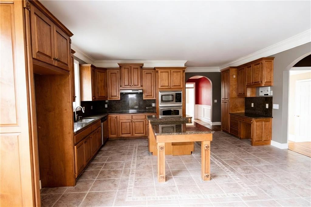 10060 Buice Road Alpharetta, GA 30022 - Photo 30 of 75 a kitchen with stainless steel appliances kitchen island granite countertop a refrigerator and cabinets