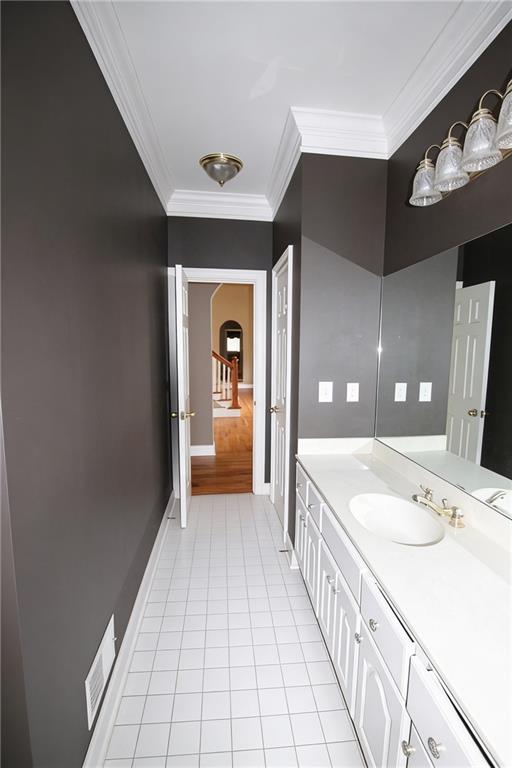 10060 Buice Road Alpharetta, GA 30022 - Photo 38 of 75 a bathroom with a sink a mirror and a bathtub