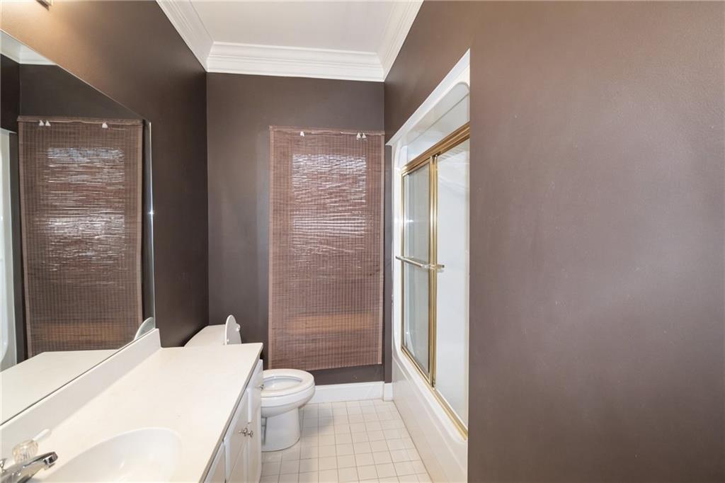 10060 Buice Road Alpharetta, GA 30022 - Photo 40 of 75 a bathroom with a toilet a sink and shower
