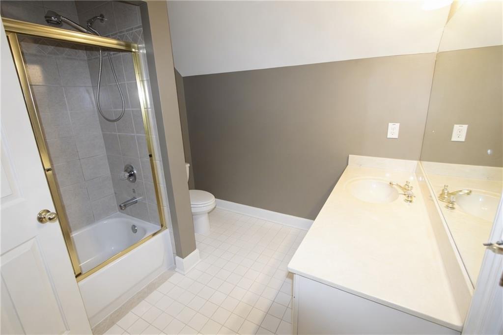 10060 Buice Road Alpharetta, GA 30022 - Photo 56 of 75 a bathroom with a bathtub and a shower