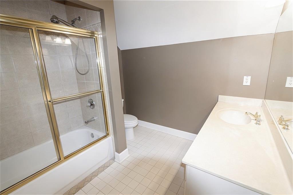 10060 Buice Road Alpharetta, GA 30022 - Photo 57 of 75 a bathroom with a sink and a glass door shower