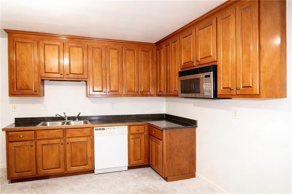 10060 Buice Road Alpharetta, GA 30022 - Photo 63 of 75 a kitchen with granite countertop a stove top oven sink and cabinets