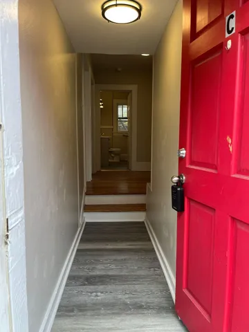 a view of a hallway with wooden floor and stairs