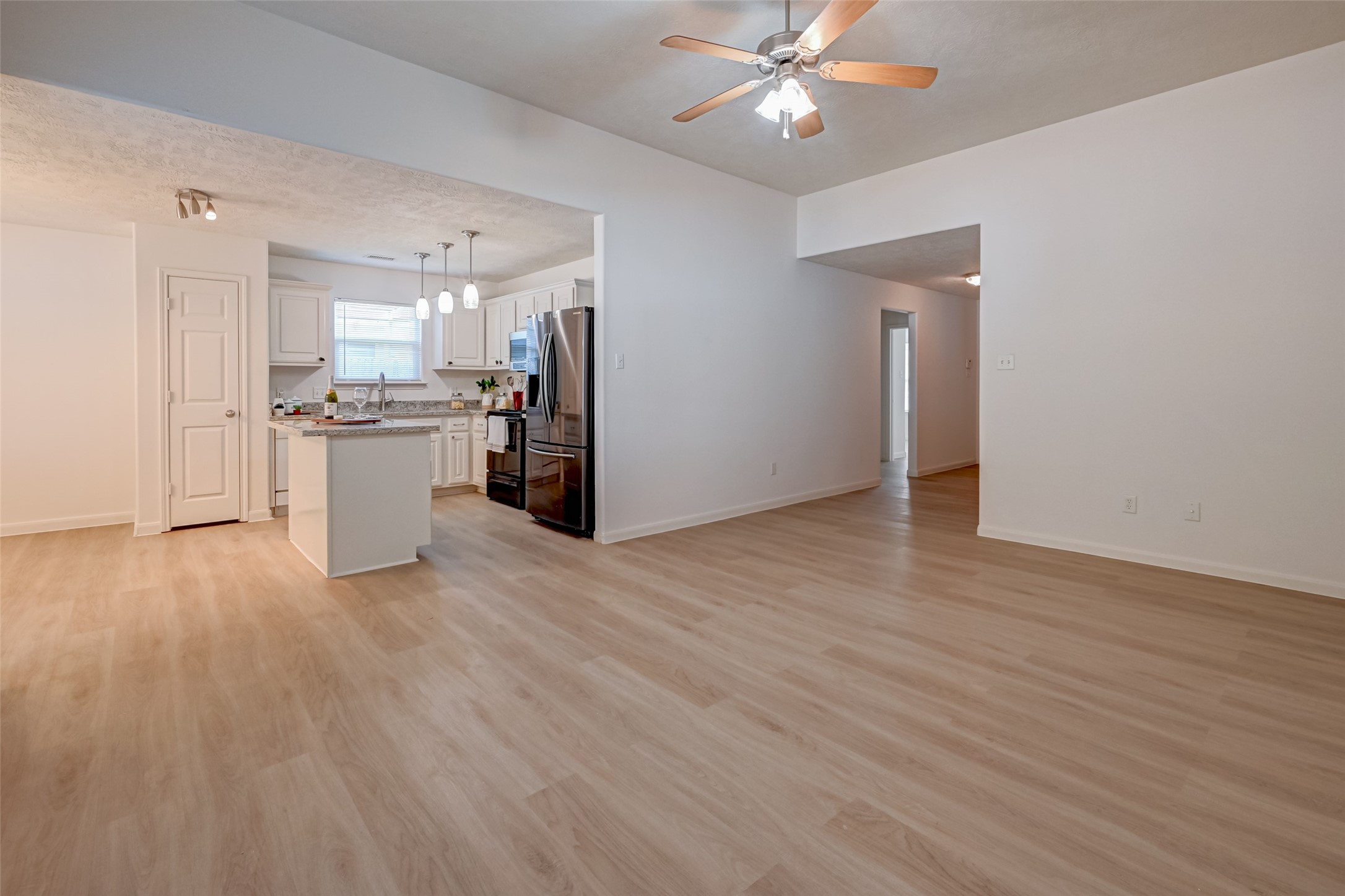 4830 Comal River Loop Spring, TX 77386 - Photo 11 of 43 a view of a kitchen with a refrigerator a ceiling fan and wooden floor