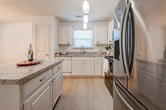 a kitchen with stainless steel appliances granite countertop a sink stove and refrigerator