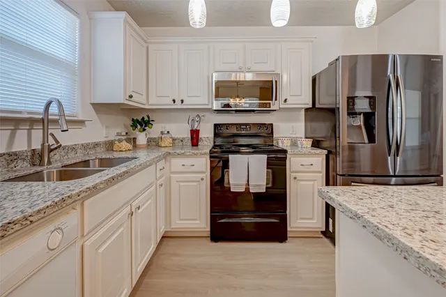a kitchen with granite countertop a refrigerator and a sink
