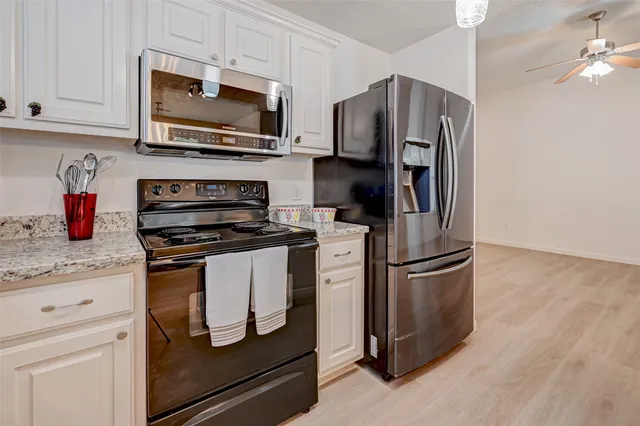 a kitchen with stainless steel appliances granite countertop a refrigerator stove and microwave
