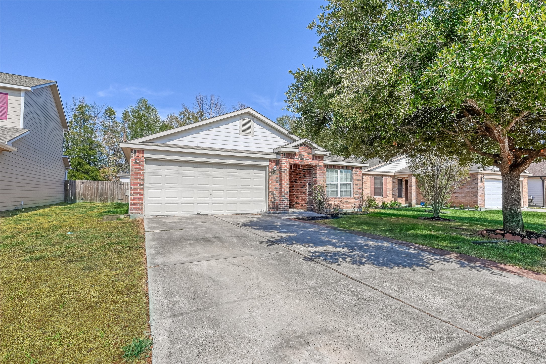 4830 Comal River Loop Spring, TX 77386 - Photo 2 of 43 a view of a yard in front of a house with plants and large tree