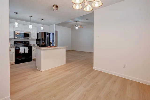 a view of kitchen with kitchen island stainless steel appliances a stove top oven