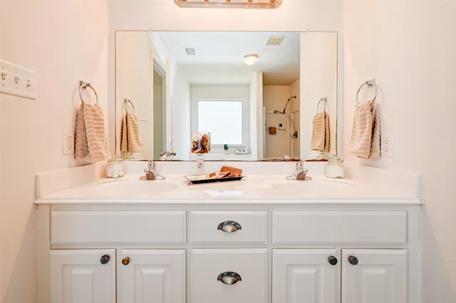 a bathroom with double vanity sinks and a mirror