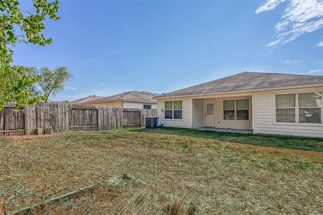 a view of a yard in front of a house with large trees