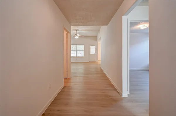 a view of a hallway with wooden floor