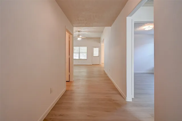 a view of a hallway with wooden floor