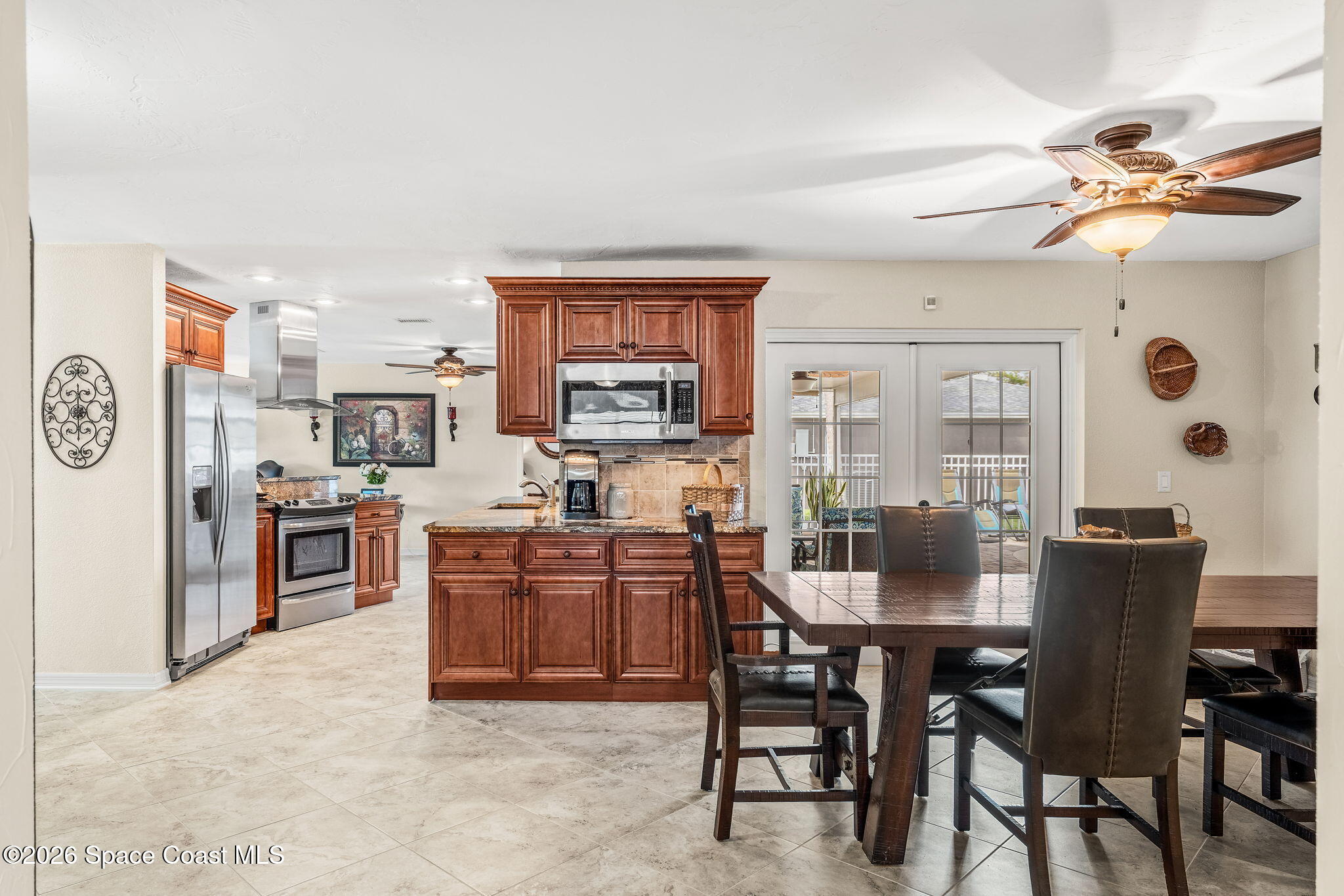 31 Fairway Drive Cocoa Beach, FL 32931 - Photo 17 of 53 a kitchen with stainless steel appliances granite countertop a stove top oven a sink a dining table and chairs