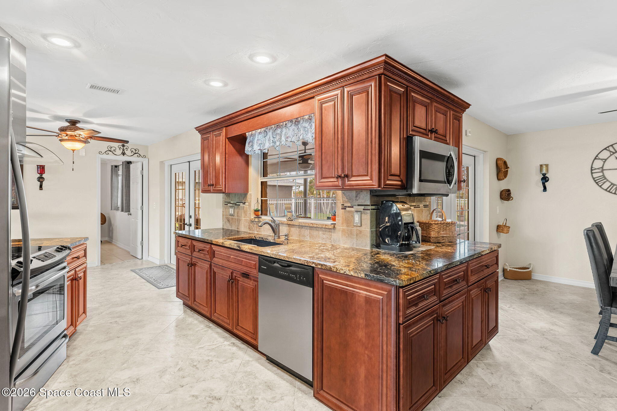 31 Fairway Drive Cocoa Beach, FL 32931 - Photo 19 of 53 a kitchen with stainless steel appliances granite countertop a stove a sink dishwasher and a refrigerator