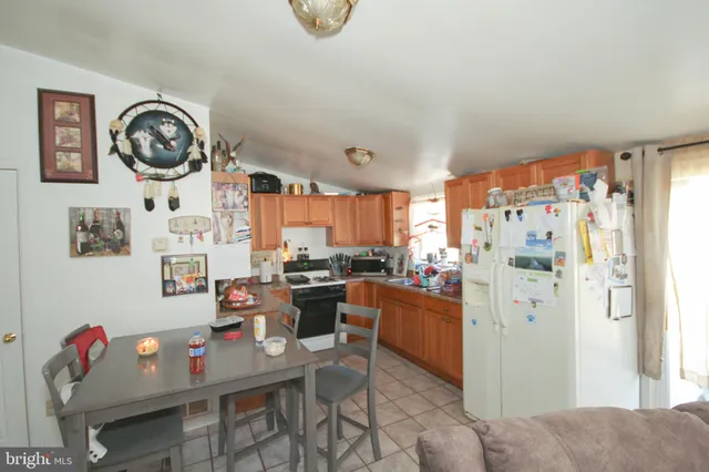 a view of kitchen with stainless steel appliances granite countertop a stove top oven a chimney and a dining table