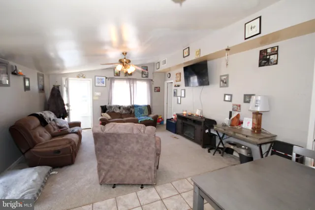 a living room with furniture a flat screen tv and a window
