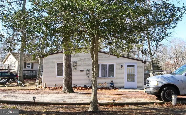a front view of a house with garden and tree
