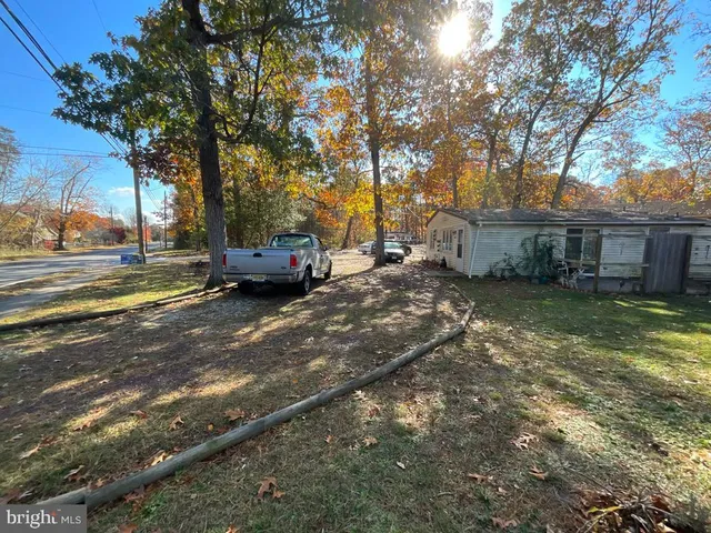 a view of a yard with a car parked in front of a house