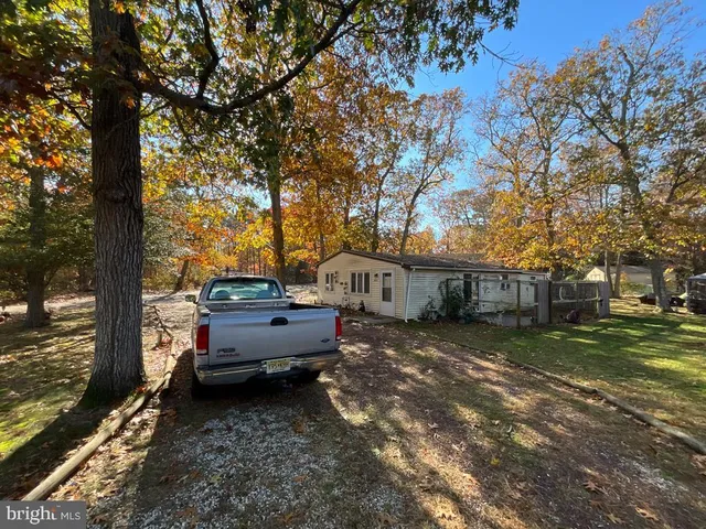 a view of a house with backyard and a tree