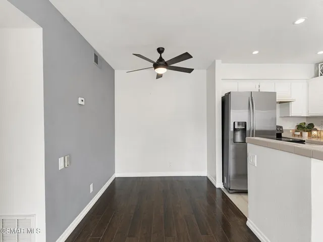 a view of a kitchen with a refrigerator and a stove top oven