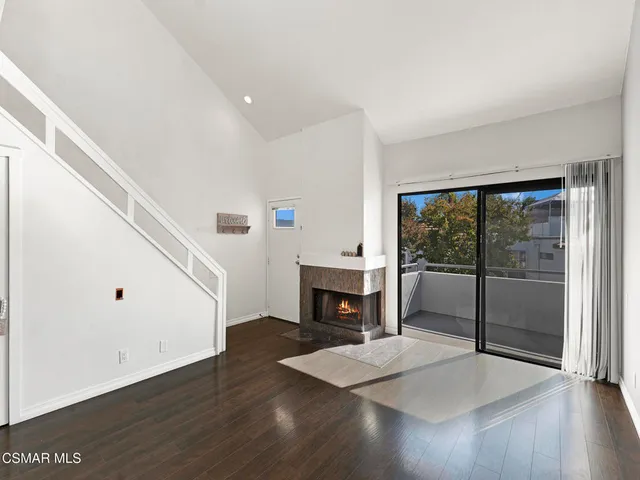 a living room with furniture wooden floor and a fireplace
